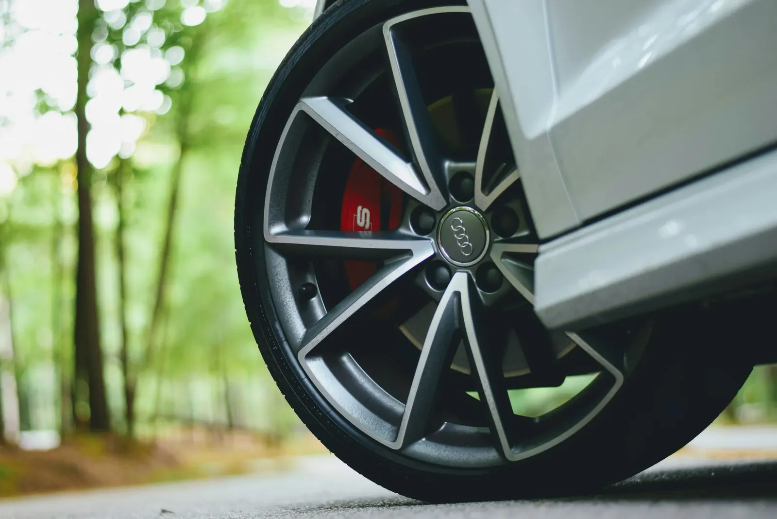 Front wheel of a white Audi with a red brake caliper